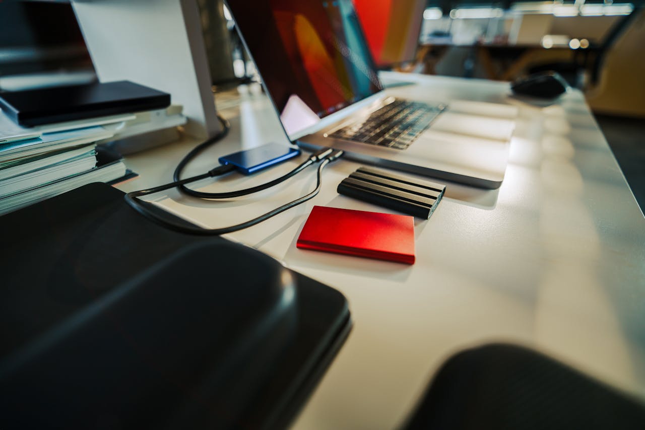 why-choose-us A neatly organized office desk featuring a laptop and several external hard drives, perfect for a digital workspace.